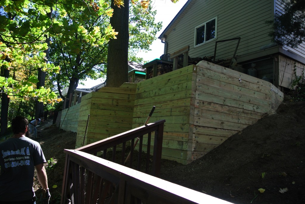 Side view of our sturdy wood retaining wall we built by hand